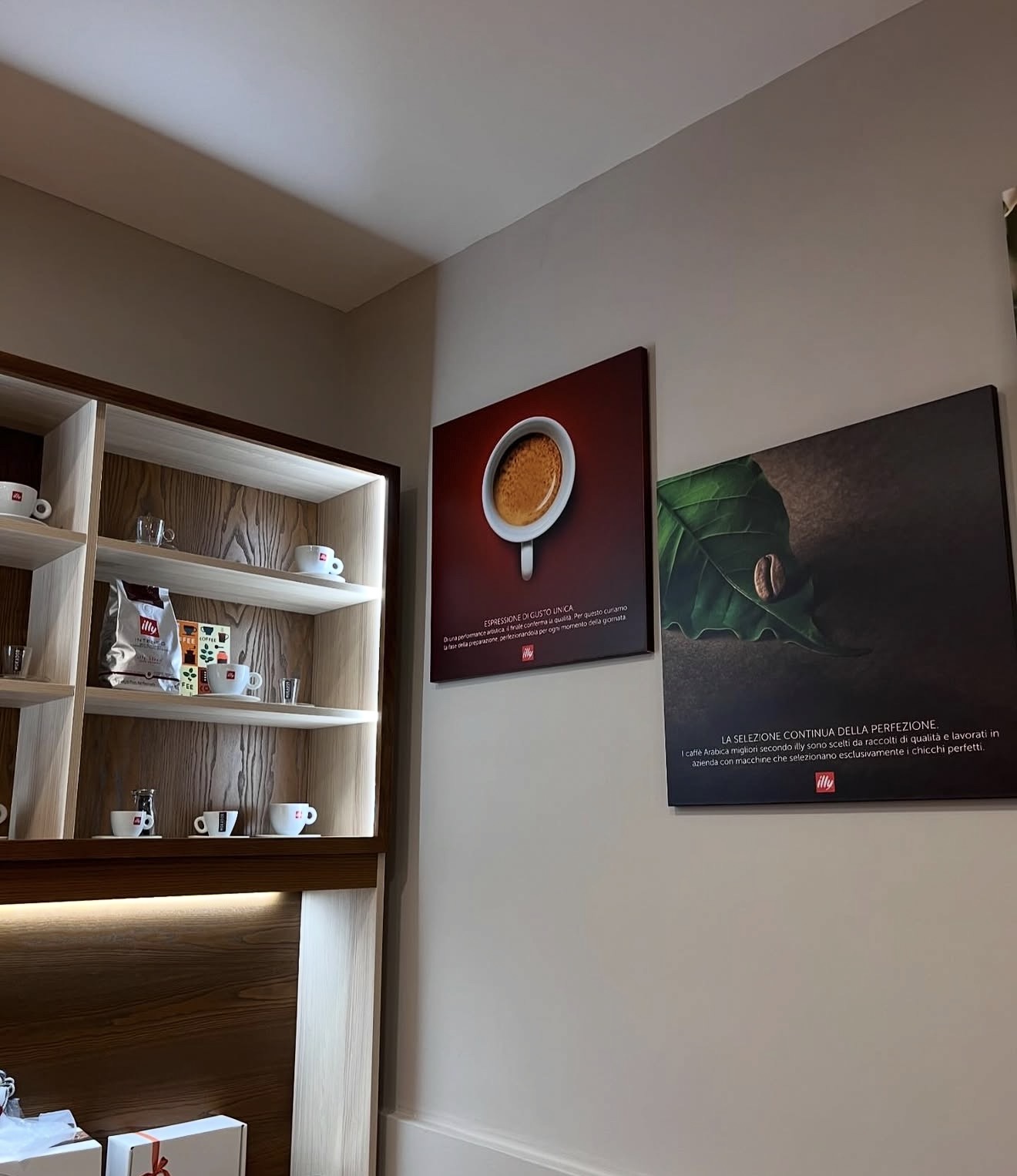 Scaffale tazzine illy e quadri nel negozio